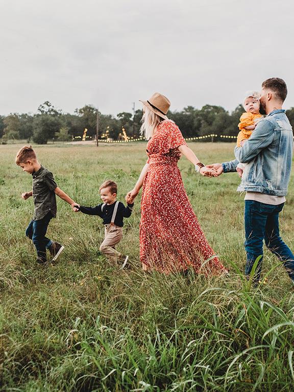 Fotografía de una familia paseando por un prado